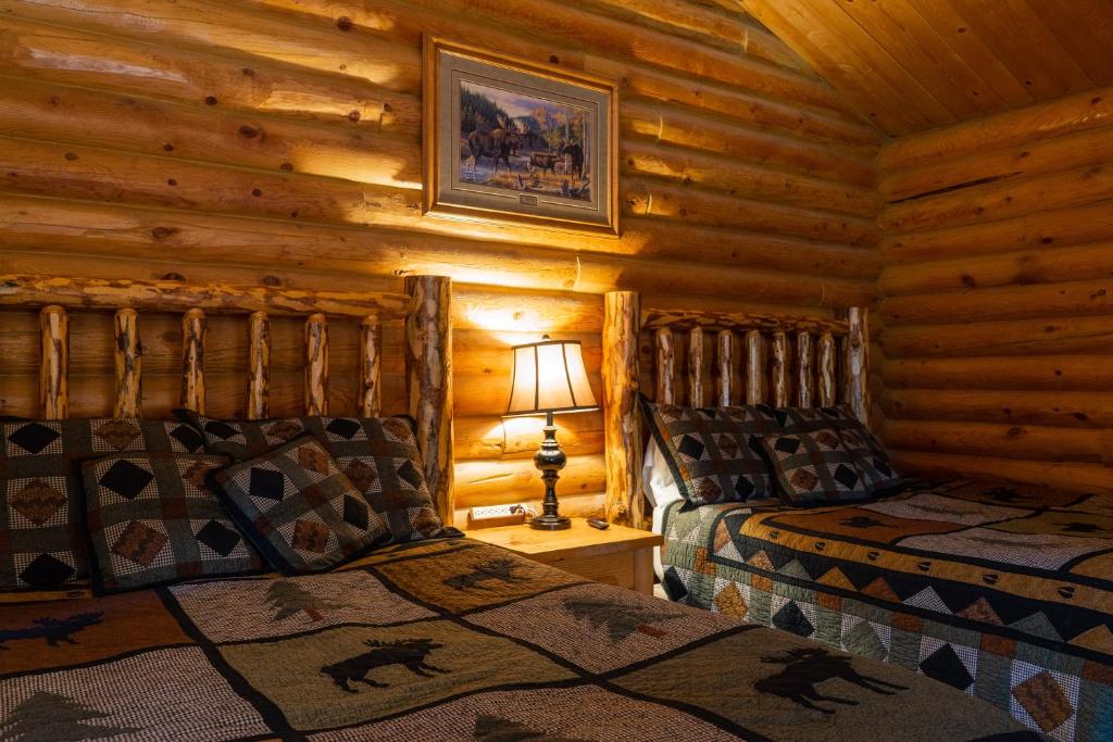 Un dormitorio con dos camas en una cabaña de madera. en Country Cabins Inn, en Lyman