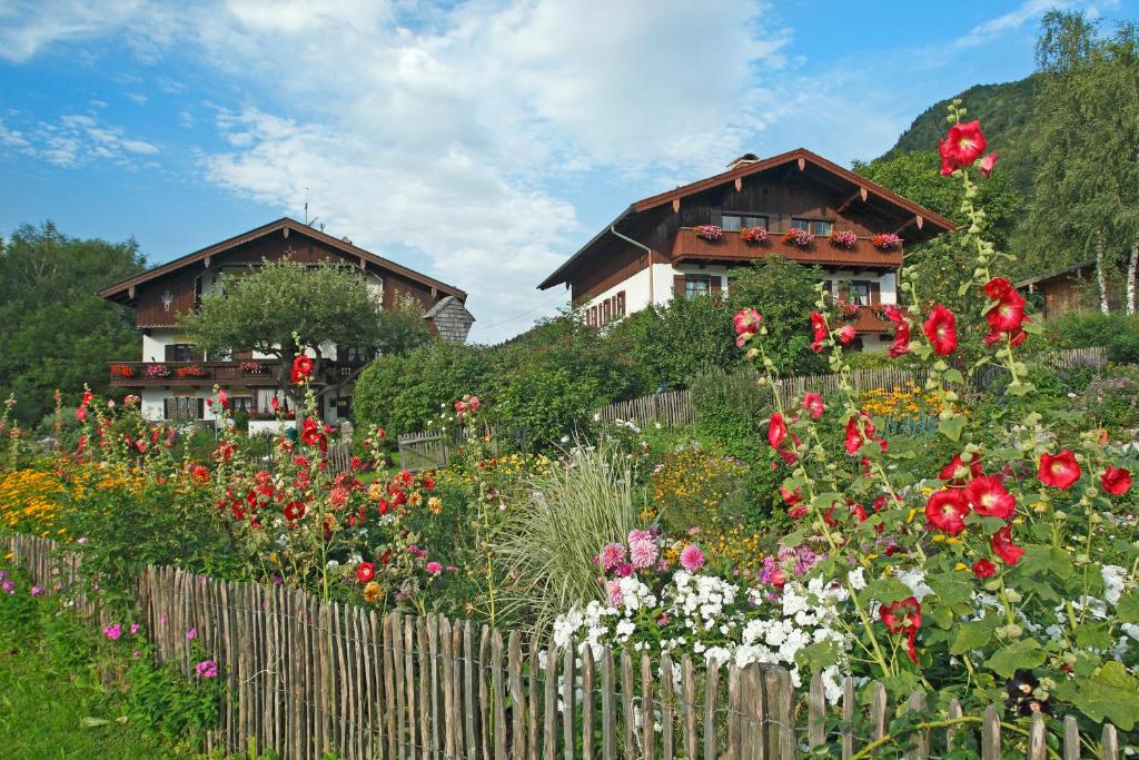 a garden with flowers in front of two houses at Gästehaus Koyerbauer Boardinghouse in Aschau im Chiemgau