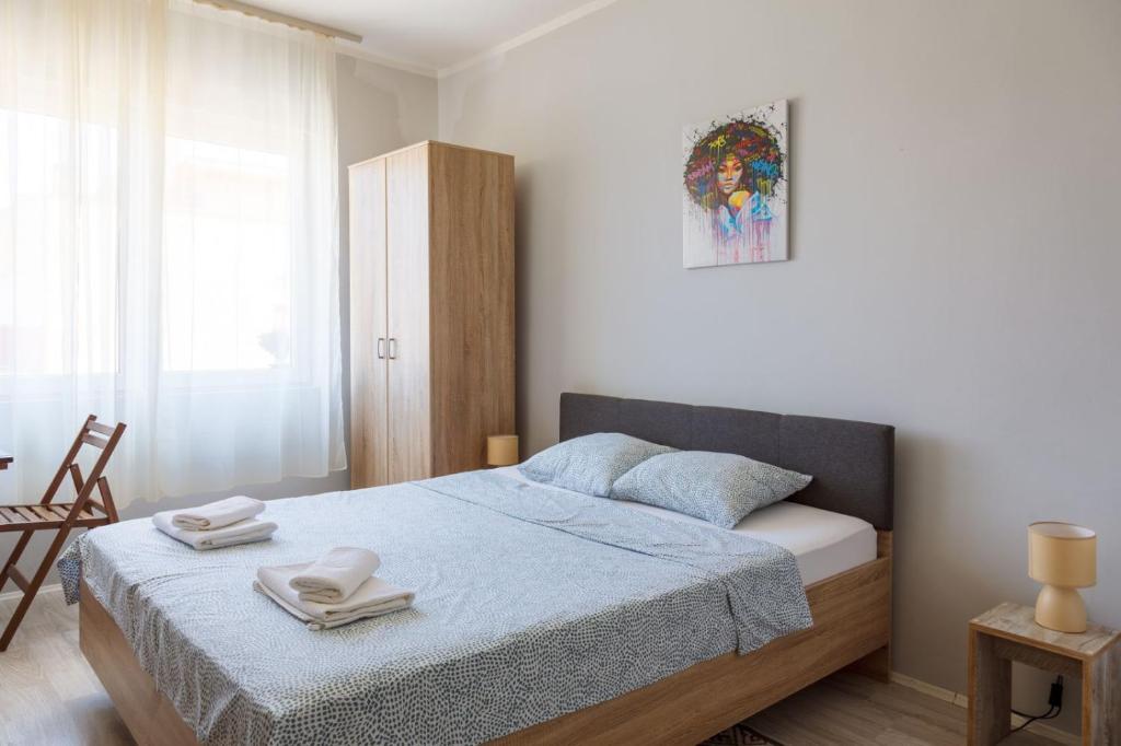 a bedroom with a bed with two towels on it at Aloha - Sobe sa kupatilom in Golubac