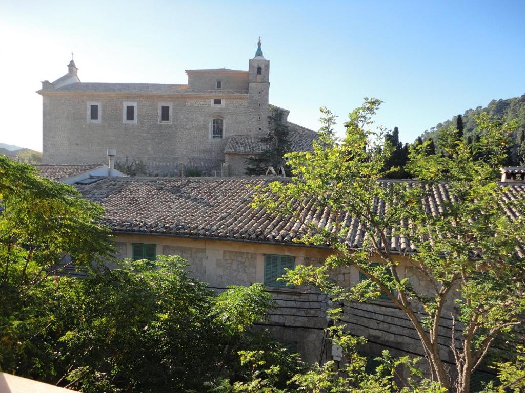 un château au sommet d'une colline plantée d'arbres dans l'établissement Allotjaments Serra de Tramuntana, à Valldemossa