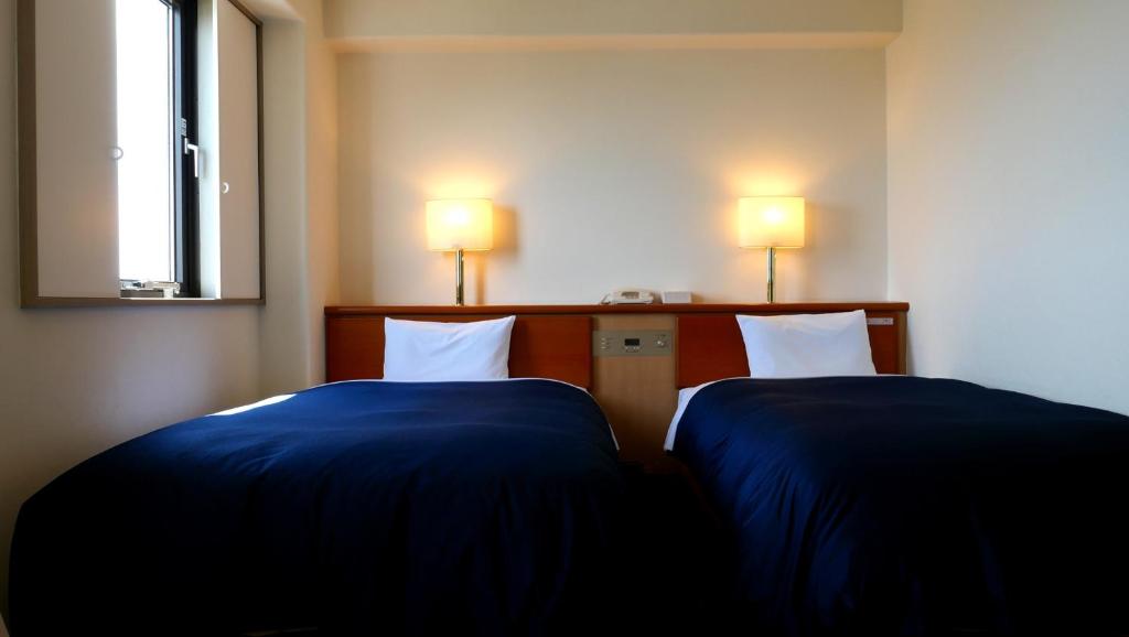 Postel nebo postele na pokoji v ubytování Tourist Hotel Hitachi