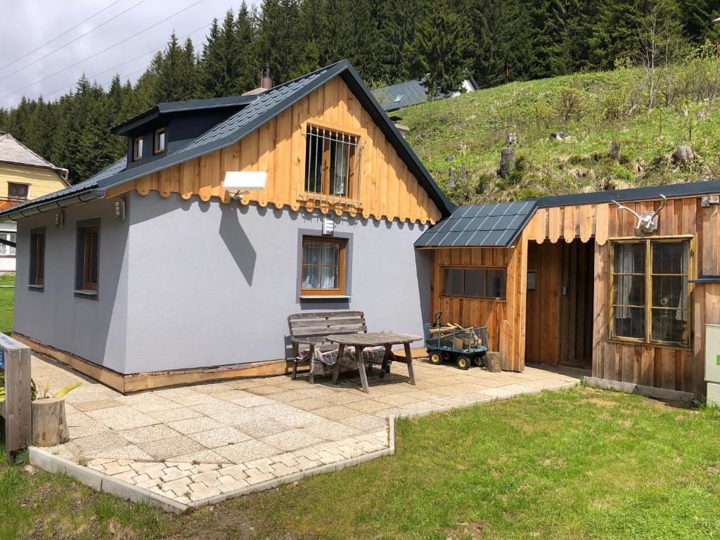 a small house with a patio and a table at Einser Hütte GesbR - Selbstversorgerhaus für 7 Personen in Vordernberg