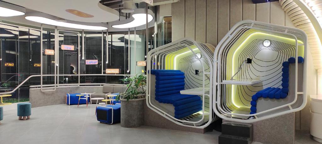 a lobby with two luggage chairs and tables at YELLO Hotel Kuta Beachwalk Bali in Kuta