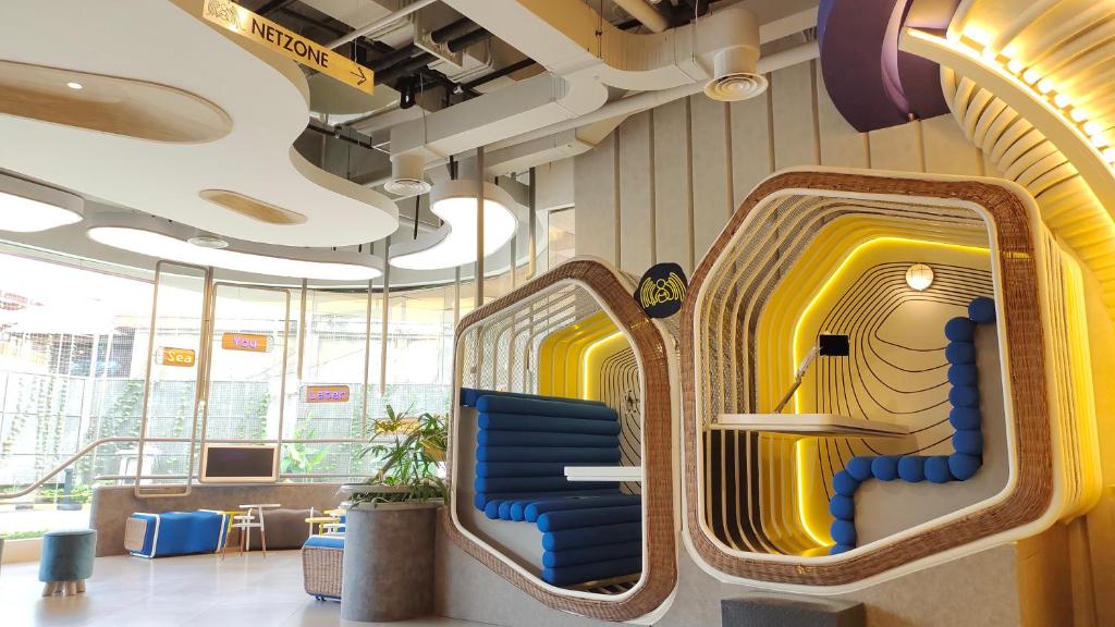 a waiting room with two blue chairs and yellow doors at YELLO Hotel Kuta Beachwalk Bali in Kuta