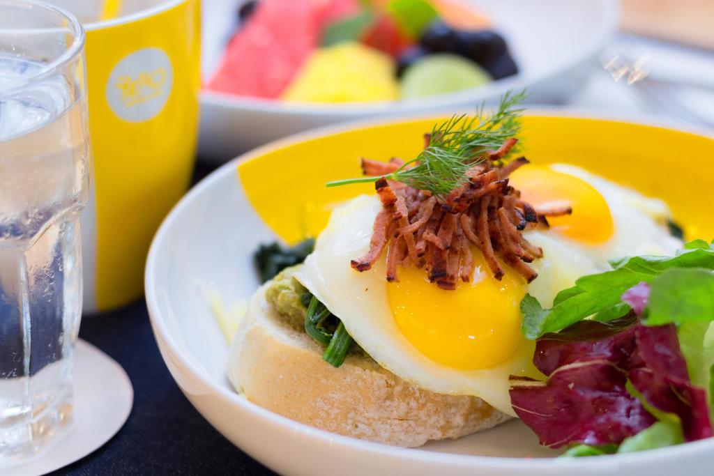a plate of food with an egg and a salad at YELLO Hotel Kuta Beachwalk Bali in Kuta
