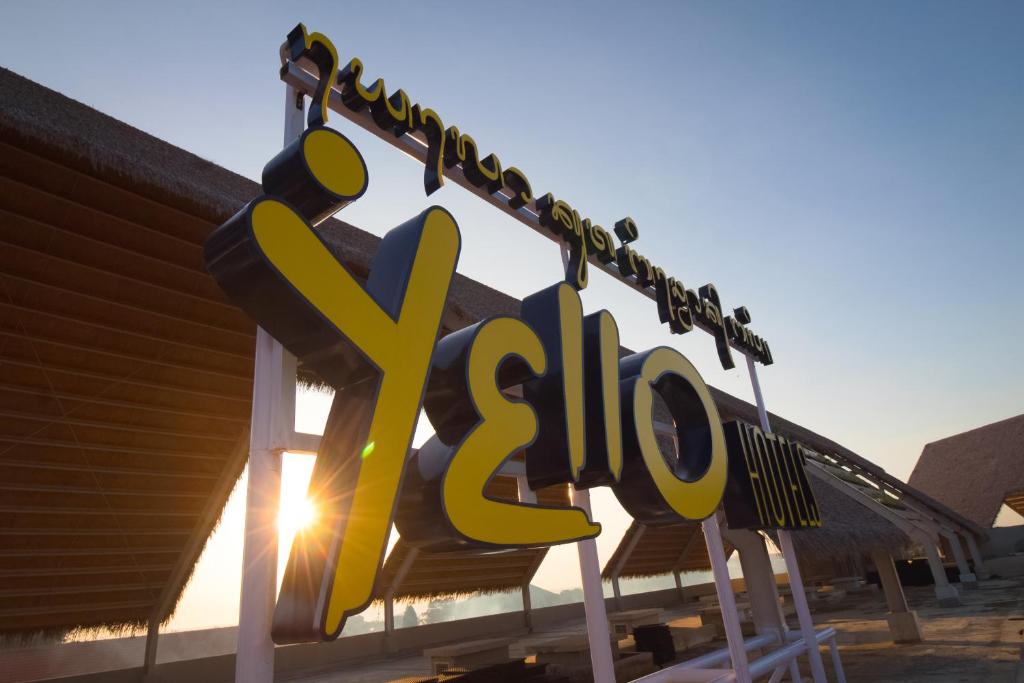 a sign for a ski resort with the sun behind it at YELLO Hotel Kuta Beachwalk Bali in Kuta