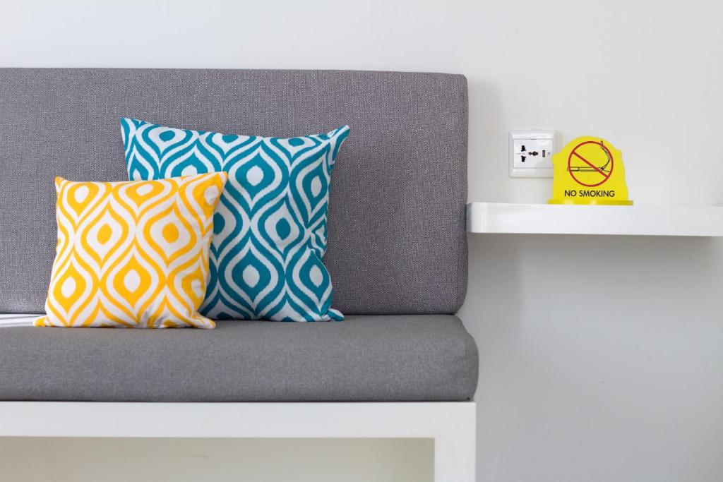 a bed with two pillows on top of it at YELLO Hotel Kuta Beachwalk Bali in Kuta