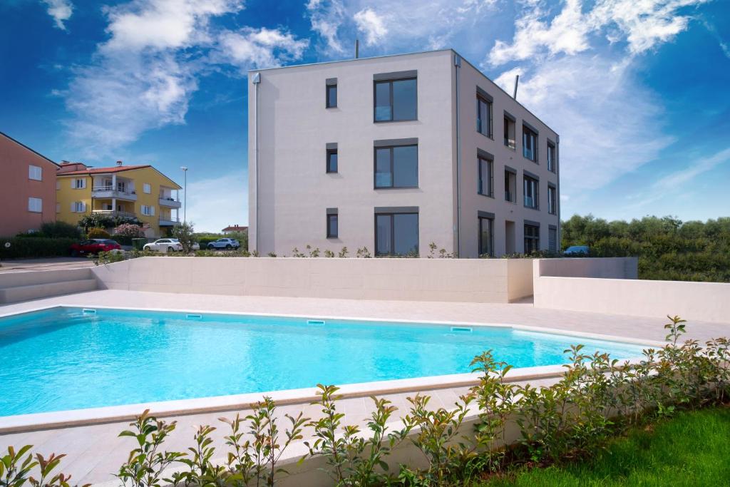 a building with a swimming pool in front of a building at The Blueview Appartements Novigrad in Novigrad Istria