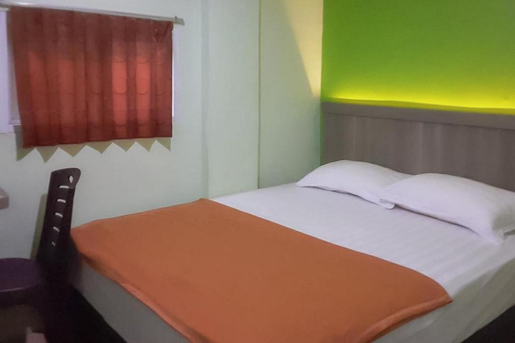 Postel nebo postele na pokoji v ubytování Guest House Anak Raja Pangkalan Bun Syariah Mitra RedDoorz