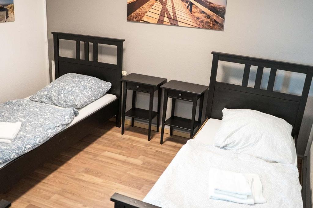 a room with two beds and two end tables at Cozy "Work and Stay" House in Burscheid