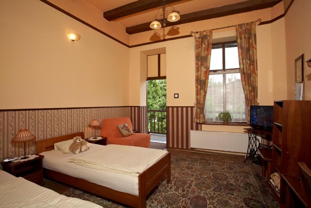 um quarto com uma cama, uma cadeira e uma televisão em Globtroter Guest House na Cracóvia