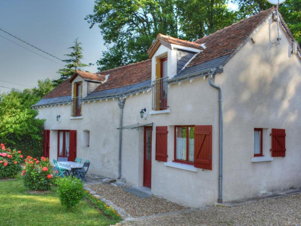 a white house with red shutters and a yard at Gîte Azay-sur-Cher, 4 pièces, 5 personnes - FR-1-381-220 in Azay-sur-Cher