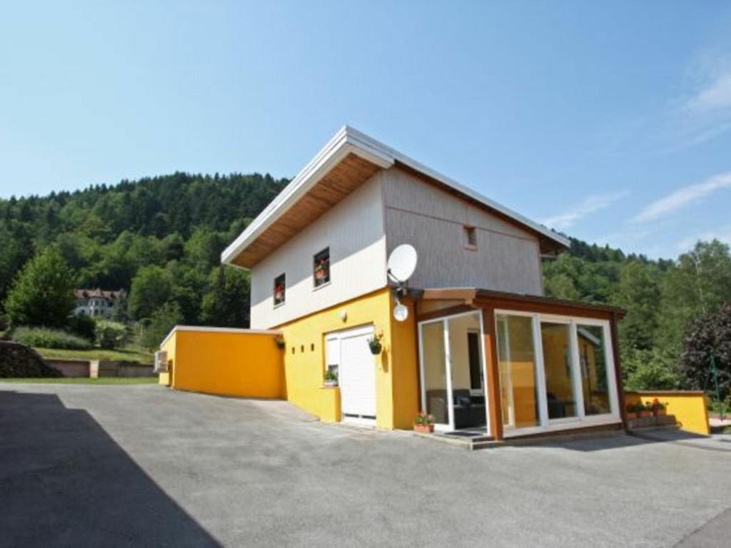 um edifício amarelo e branco com garagem em Gîte Le Menil, 3 pièces, 6 personnes - FR-1-589-111 em Le Ménil