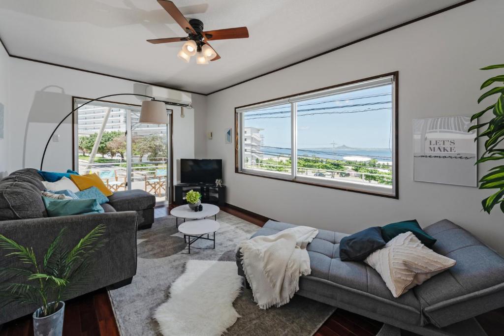 Ocean View Terrace BISE في موتوبو: غرفة معيشة مع أريكة ومروحة سقف