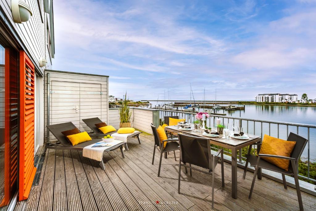 eine Terrasse mit einem Tisch und Stühlen auf dem Balkon in der Unterkunft Ab ans Meer in Olpenitz