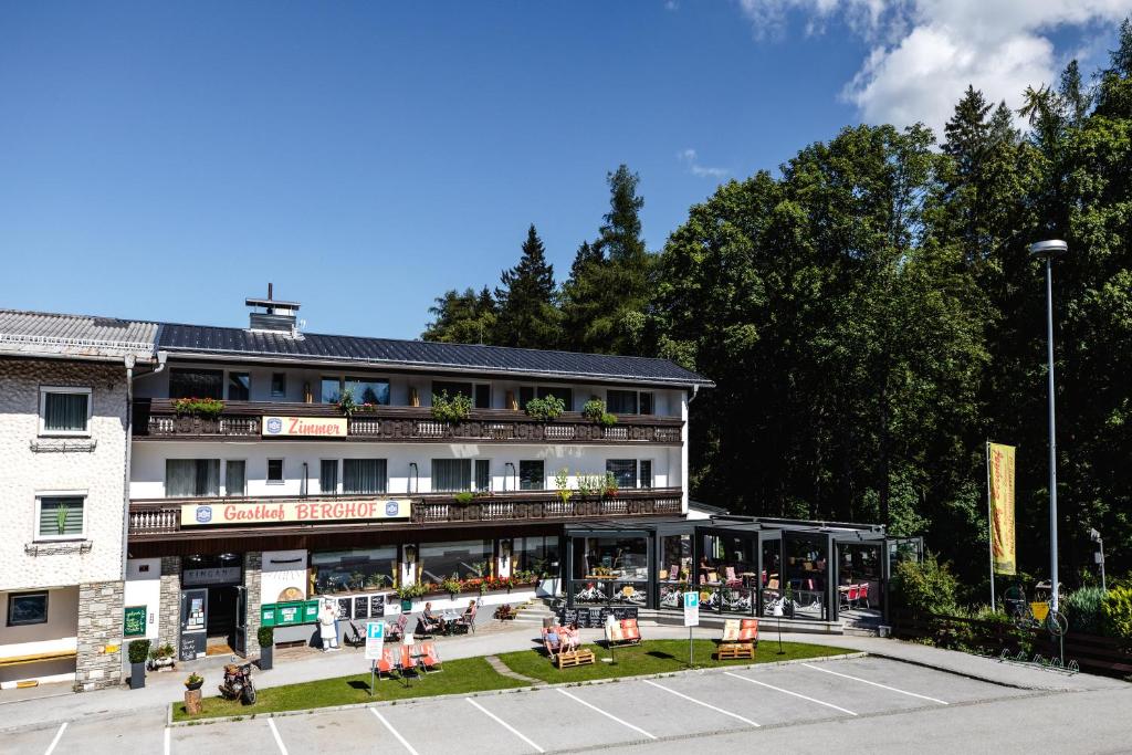 ein Hotel mit Tischen und Stühlen auf einem Parkplatz in der Unterkunft Gasthof Berghof in Semmering