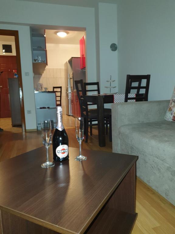 - une bouteille de vin assise sur une table avec deux verres dans l'établissement Apartman Basic Doboj, à Doboj