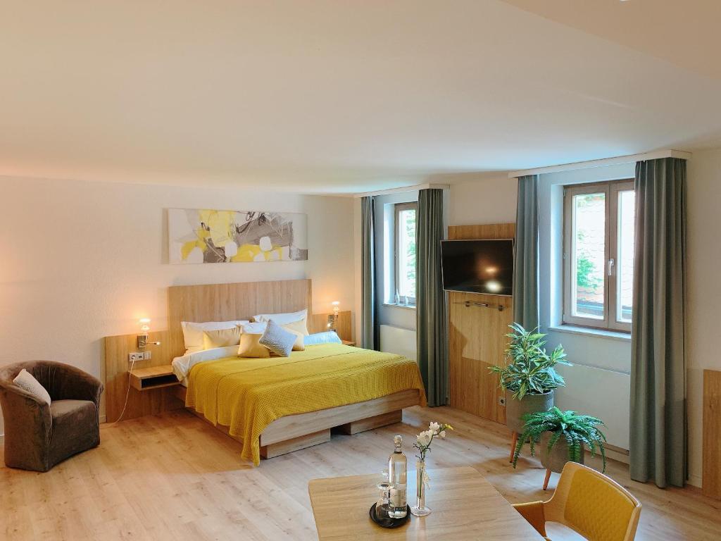 グンツェンハウゼンにあるHotel Blauer Wolfのベッドルーム(黄色のベッド1台、テーブル付)