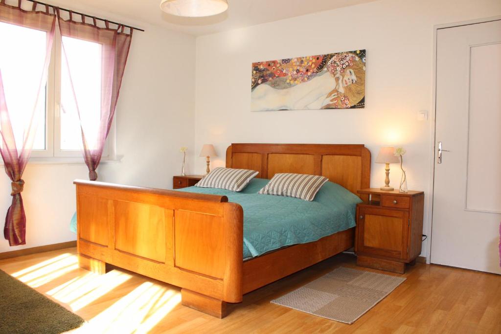 een slaapkamer met een bed met een houten bedframe bij Le Vent d'Ange in Zellenberg