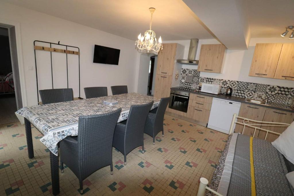 eine Küche mit einem Esstisch und Stühlen in der Unterkunft Gîtes du Franc Rosier 2 in Rigny-Ussé