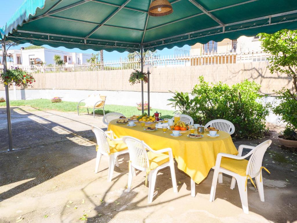 une table et des chaises sous un parasol vert dans l'établissement Villa Li Campi, à Massa Lubrense