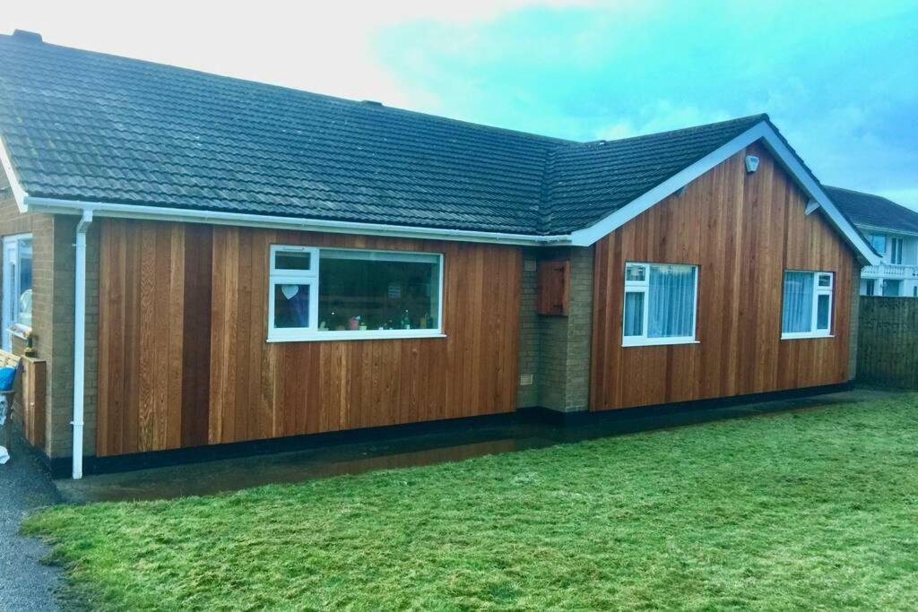 a timber house with a pitched roof at Shore Lodge. 4 bed bungalow only mtrs from the beach. Sleeps 8 in Sutton on Sea