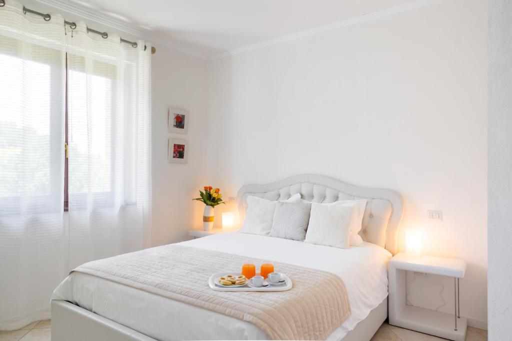 a white bedroom with a white bed with oranges on a tray at Villa Colle di Rocco in Cannara