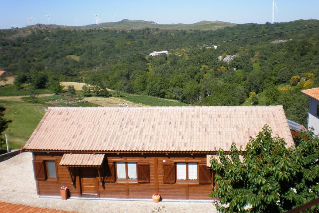 una pequeña casa de madera con techo en una colina en Casas de Montanha da Gralheira, en Gralheira