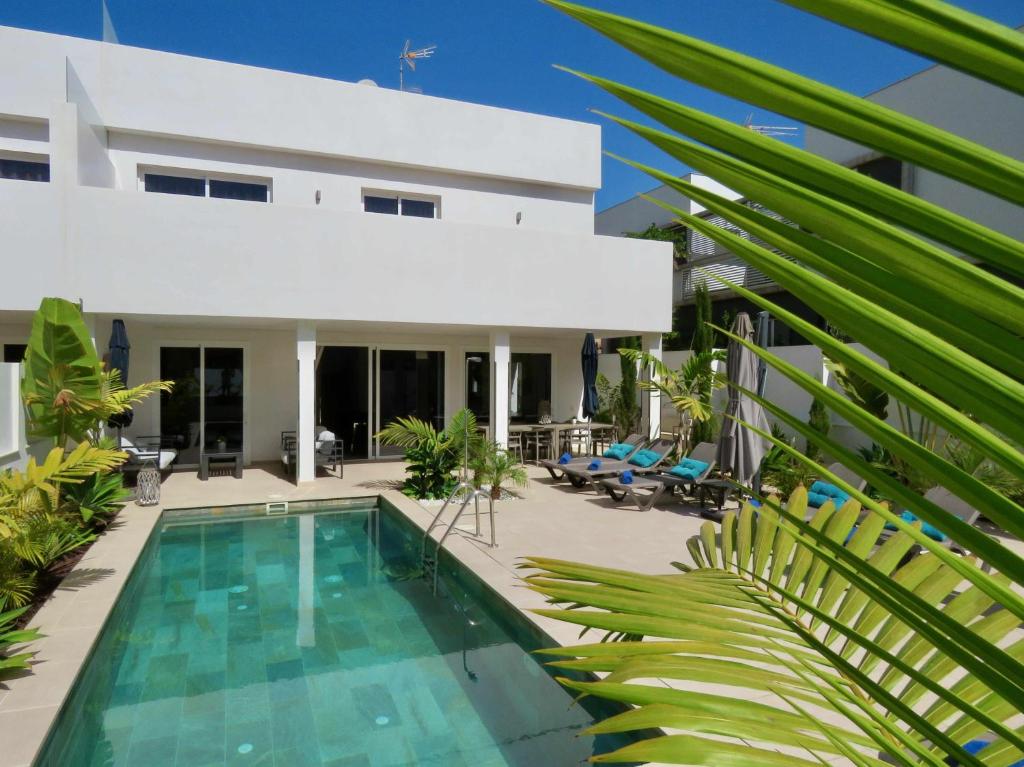 a villa with a swimming pool and a house at Villa Palm Breeze in Maspalomas