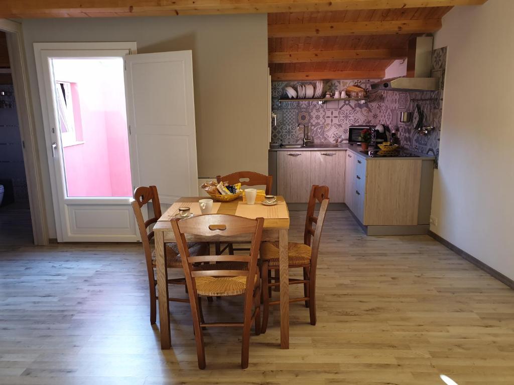 kuchnia z drewnianym stołem i krzesłami w pokoju w obiekcie Locazione turistica da Enzo e Maria w mieście Ragusa