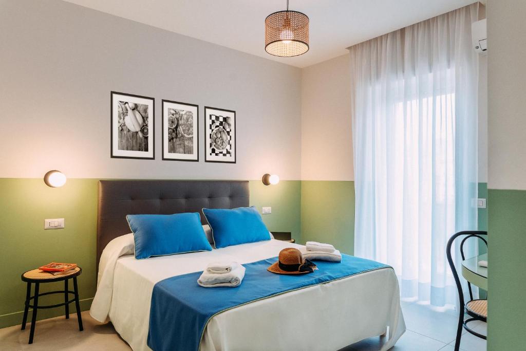 Schlafzimmer mit einem Bett mit blauen und grünen Wänden in der Unterkunft Sorrento Colors&Suites in Sorrent
