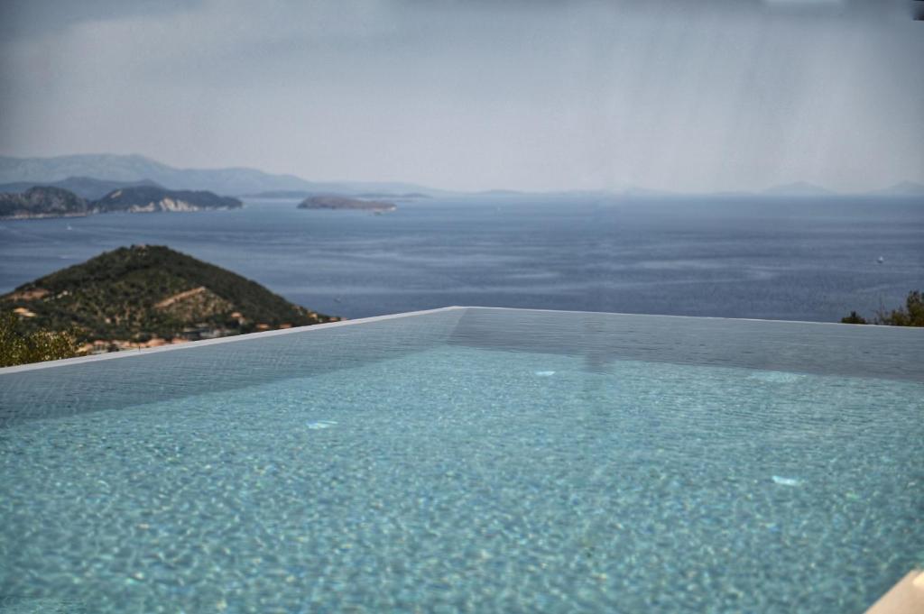 a swimming pool with a view of the ocean at Blooms of Sivota Bay - Luxury villas with private heated pool in Sivota
