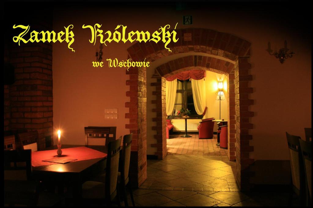 un letrero iluminado en un restaurante con una vela en una mesa en Zamek Królewski we Wschowie, en Wschowa