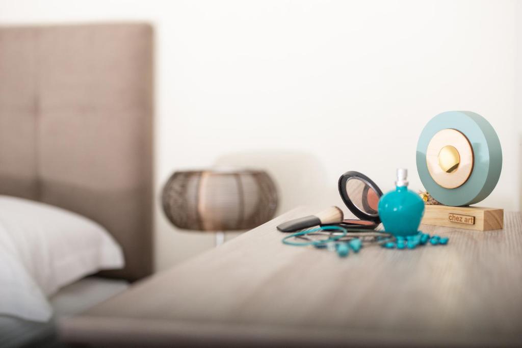 a table with a lamp and a candle on a bed at Crist Luxury Apartments in Nea Potidaea