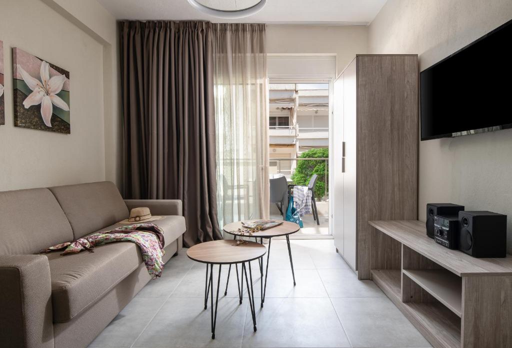 a living room with a couch and a table at Crist Luxury Apartments in Nea Potidaea