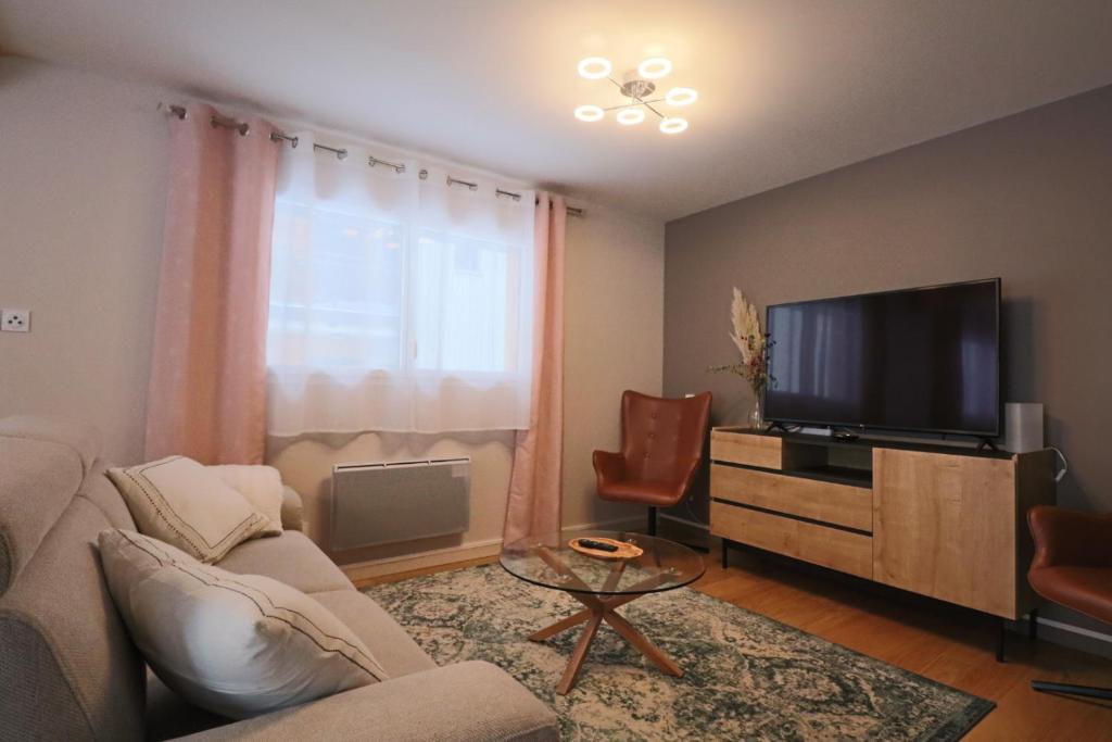 salon z kanapą i telewizorem w obiekcie La Petite Montille w mieście Mont-Dore