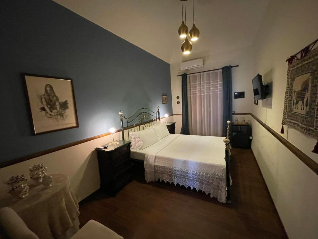 ein Schlafzimmer mit einem Bett mit einer weißen Tagesdecke in der Unterkunft Guest House Le ginestre dell'Etna in Belpasso