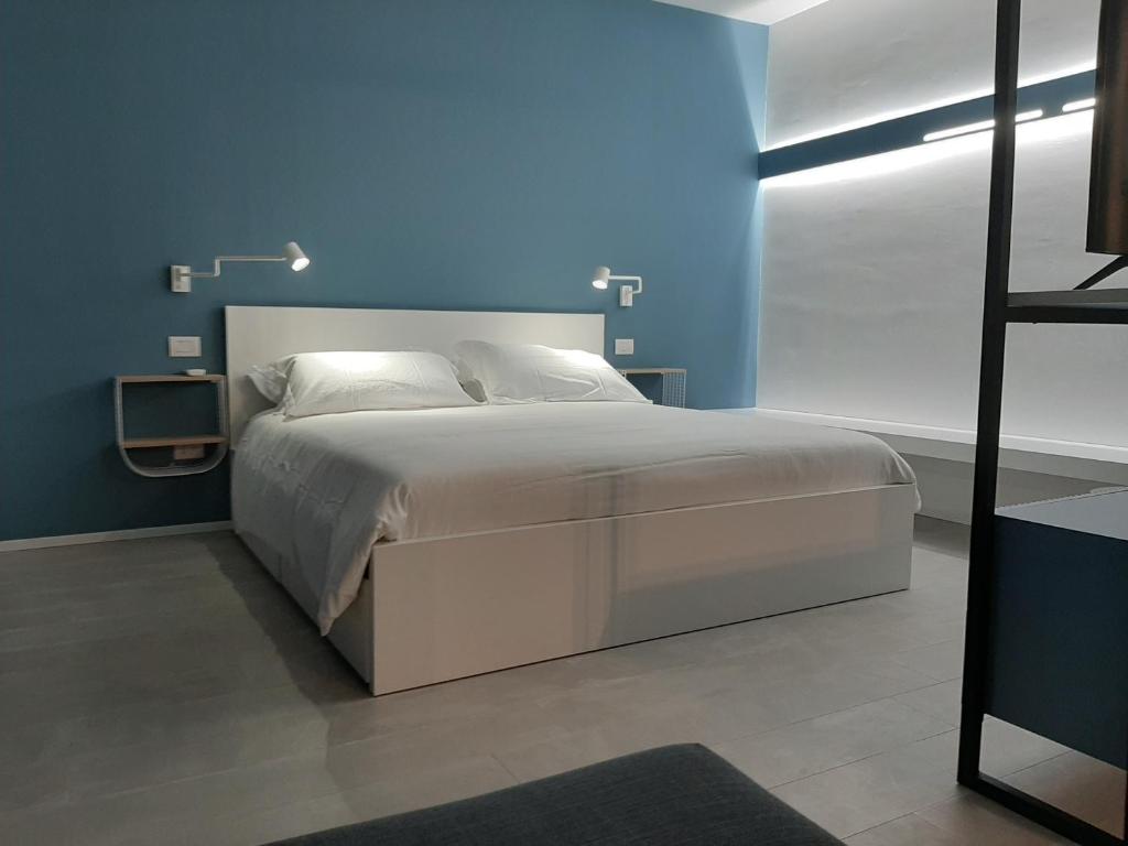 a bedroom with a large bed with a blue wall at Kore Home in Olbia