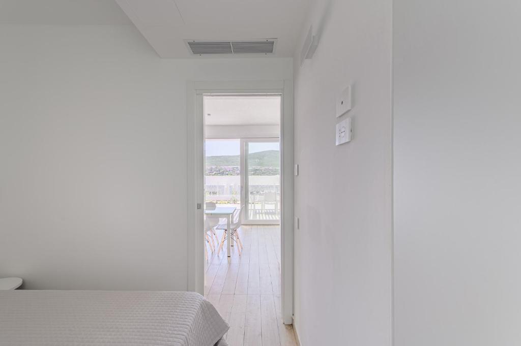 a bedroom with a bed and a view of a table at Capo Falcone Charming Apartments in Stintino