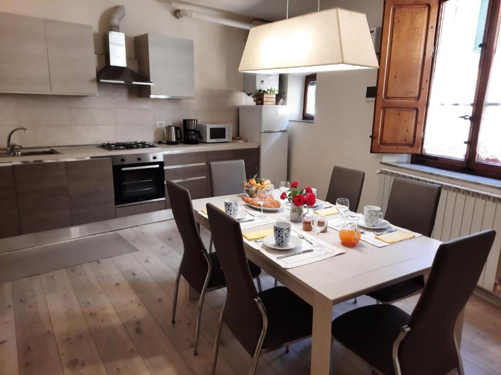 a kitchen with a table and chairs in a kitchen at Palazzo Colombini Apartment in Lucca