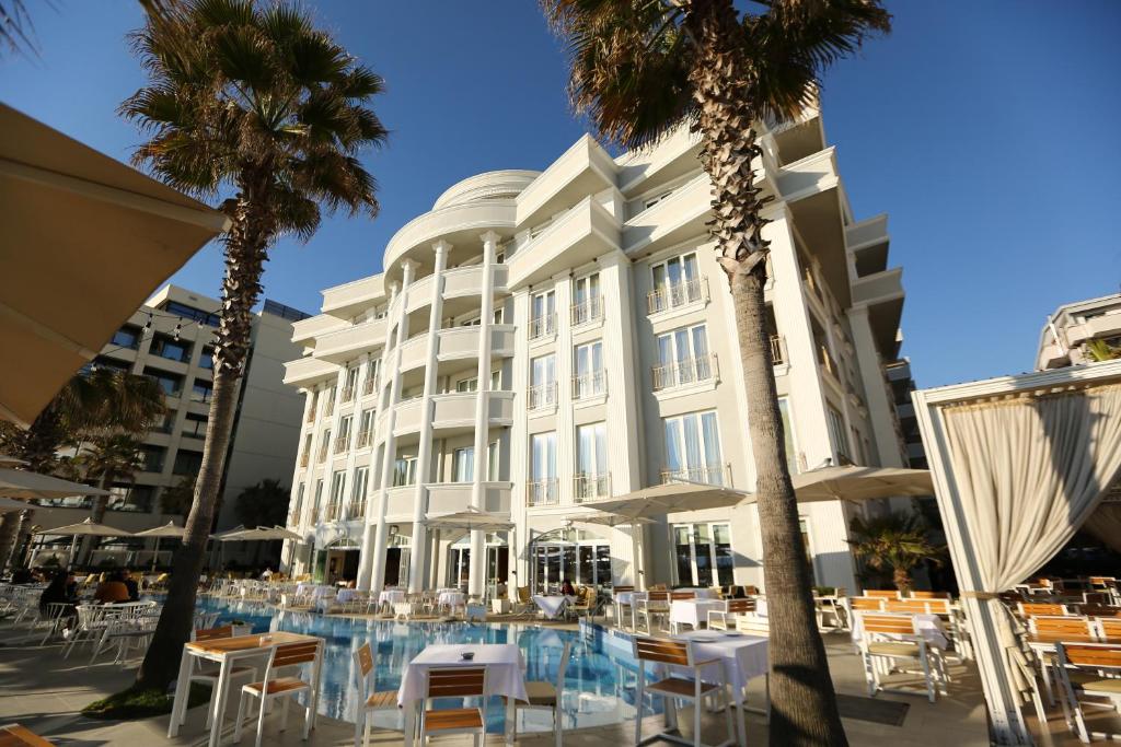 a hotel with tables and chairs in front of a building at Palace Hotel & SPA in Durrës