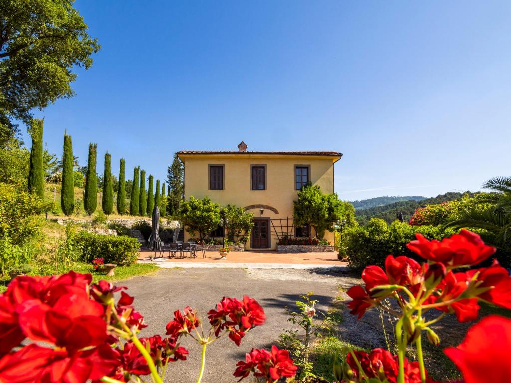 een huis met rode bloemen ervoor bij Residence al Foionco in Lucca