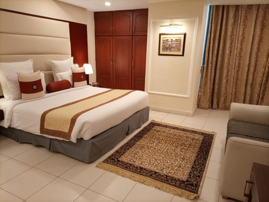 a hotel room with a large bed and a couch at Falettis Express DHA in Lahore