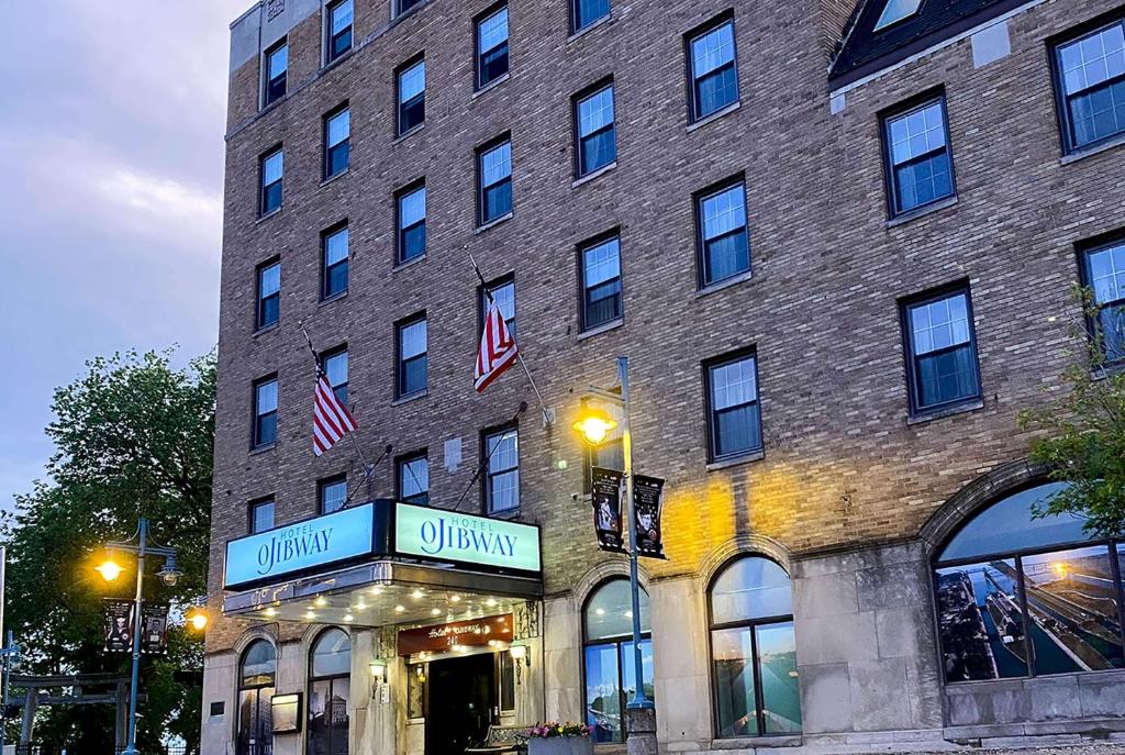 a large brick building with a store in front of it at The Hotel Ojibway, Trademark Collection by Wyndham in Sault Ste. Marie