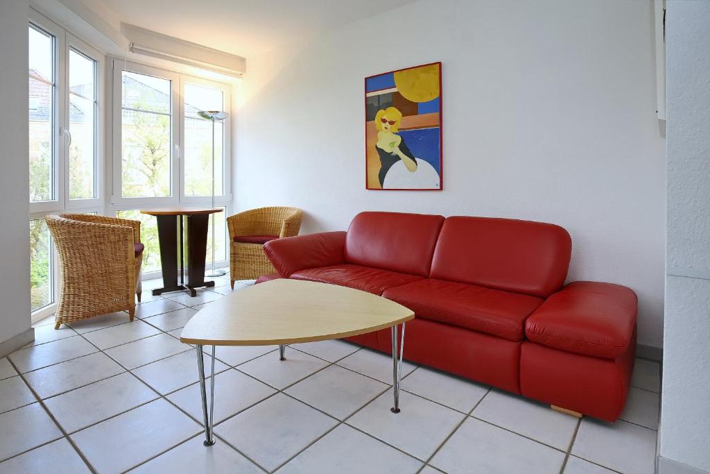 a living room with a red couch and a table at Dünenblick Wohnung 44 in Boltenhagen