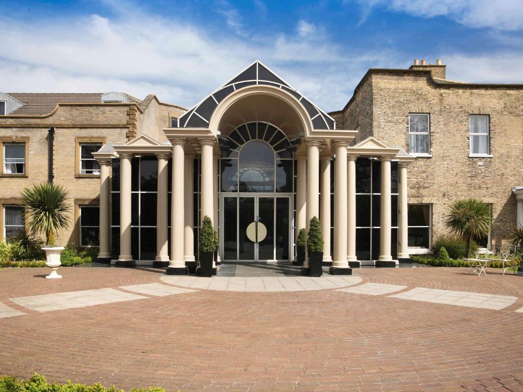 a large brick building with a large entrance at Mercure York Fairfield Manor Hotel in York