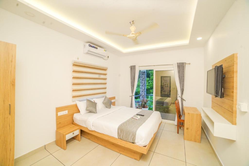 a bedroom with a bed and a tv in it at Oceana Hills Residency in Alleppey