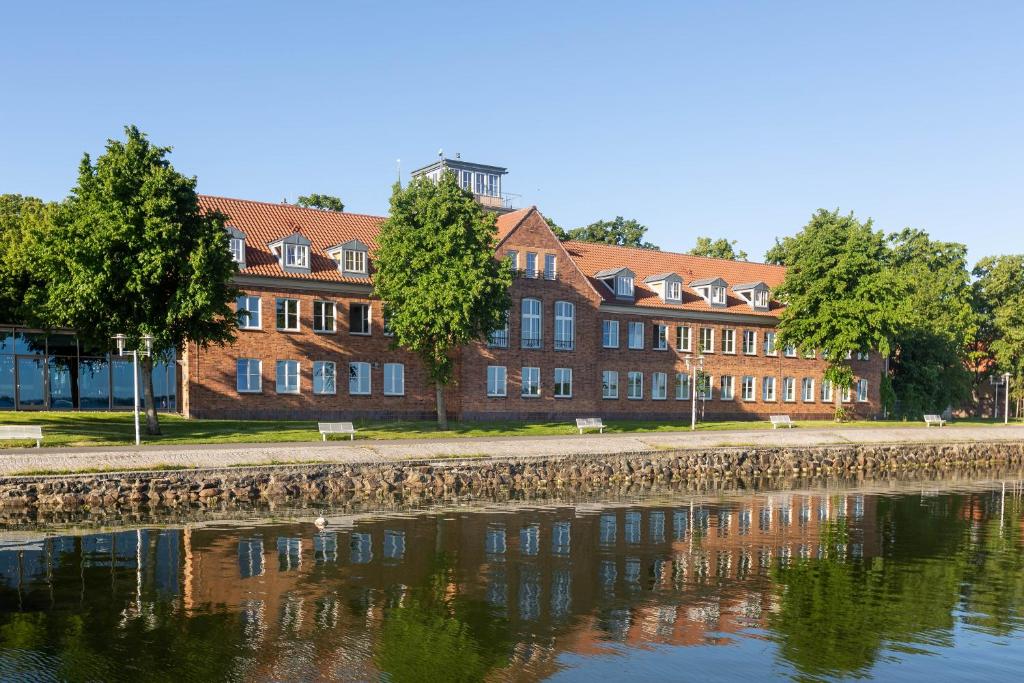 
a large brick building with a view of the water at Hotel Hafenresidenz Stralsund in Stralsund
