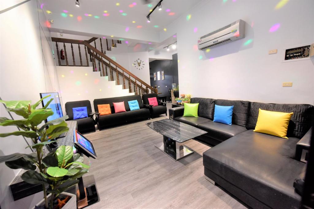 ein Wohnzimmer mit mehreren Sofas und einem Tisch in der Unterkunft 哦耶Oh Yeah 包棟民宿 in Luodong