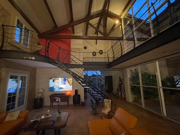 a living room with a staircase in a house at Chambres d&#39;hôtes la Soulenque Luxury B &amp; B in Capestang